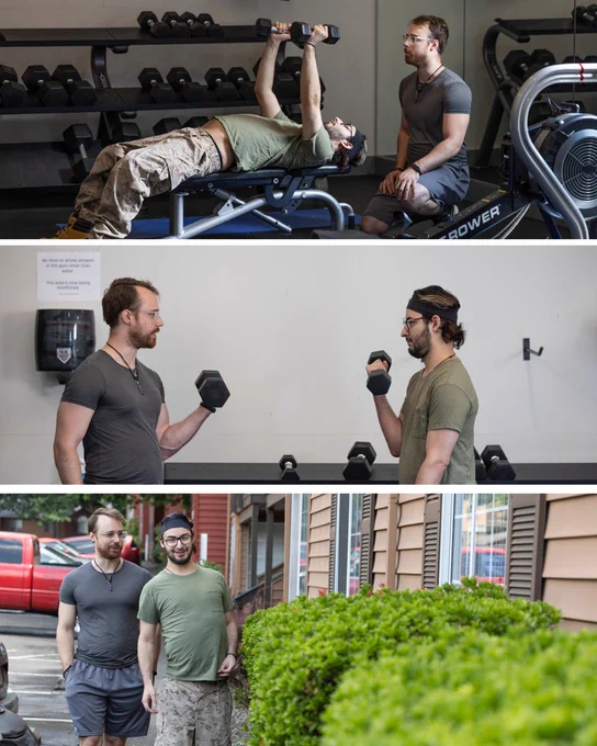 Man lying on bench press lifting dumbbells while trainer watches closely in gym.