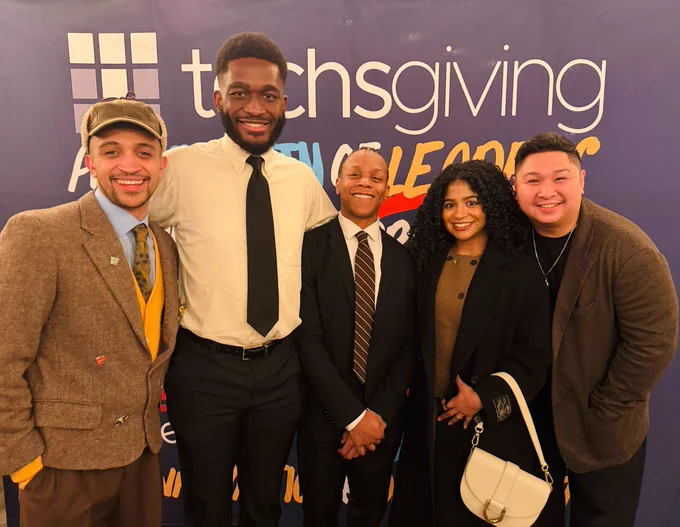 RC Alumni posed in front of the Techsgiving banner. 