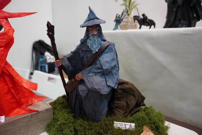 An origami of Gandalf sitting in nature.