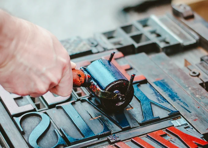 Colorful letterpress type blocks, highlighting the shift from traditional print layout to modern digital publishing with WordPress' Gutenberg interface.