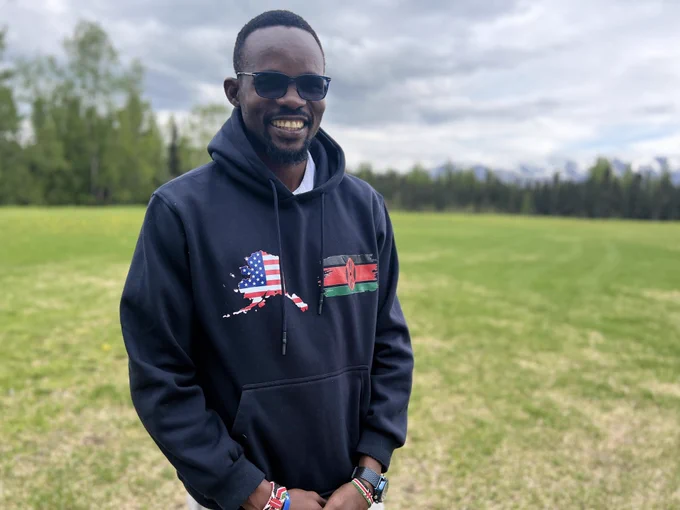 A pic of myself out in the open field, wearing navy blue hoody with US and Kenyan flag printed on