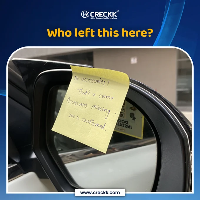 Sticky note stuck on a car’s side mirror with a handwritten message about missing accessories,  “Who left this here?”