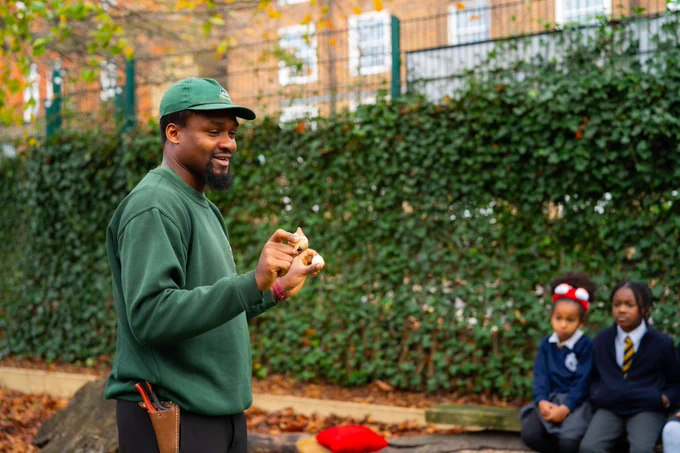 A man teaches children about planting bulbs