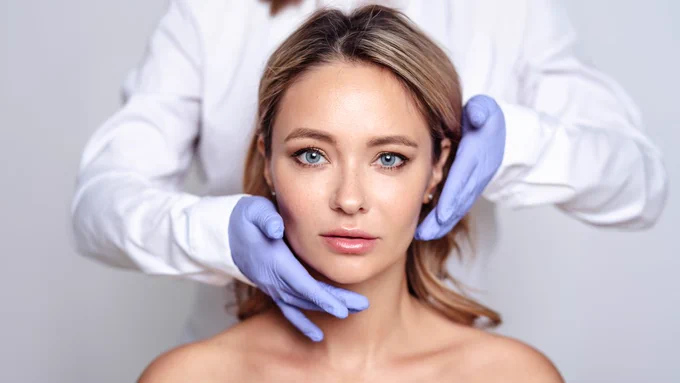 The image shows a gloved healthcare provider touching the sides of a person’s face.