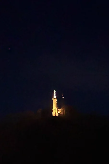 Foto in den Nachthimmel, Bild mittig die hell erleuchtete Mariensäule