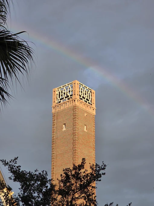 Rainbow arching over the Hulley Tower at Stetson University during a cloudy sunset.