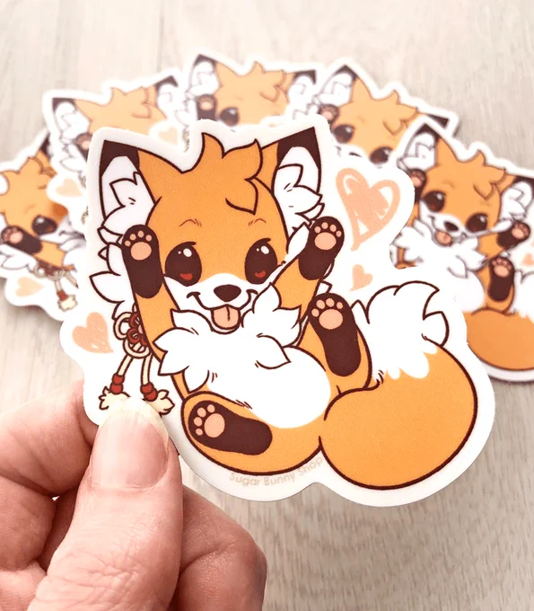 A vinyl sticker depicting a playful cartoon fox character, Doki, with a cute expression, sitting and begging for a tummy rub.