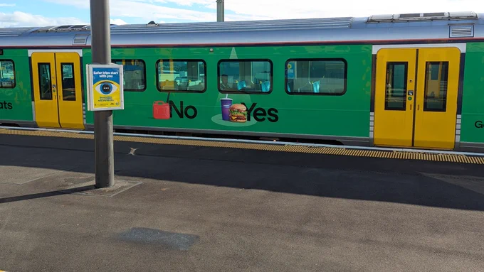A train wrapped with an ad for Uber Eats, reading Fuel: No, BurgerFuel: Yes