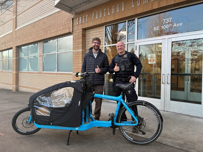 A blue bike and its owner along with a police officer.