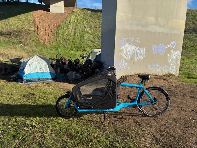 A blue bike in front of a camp.