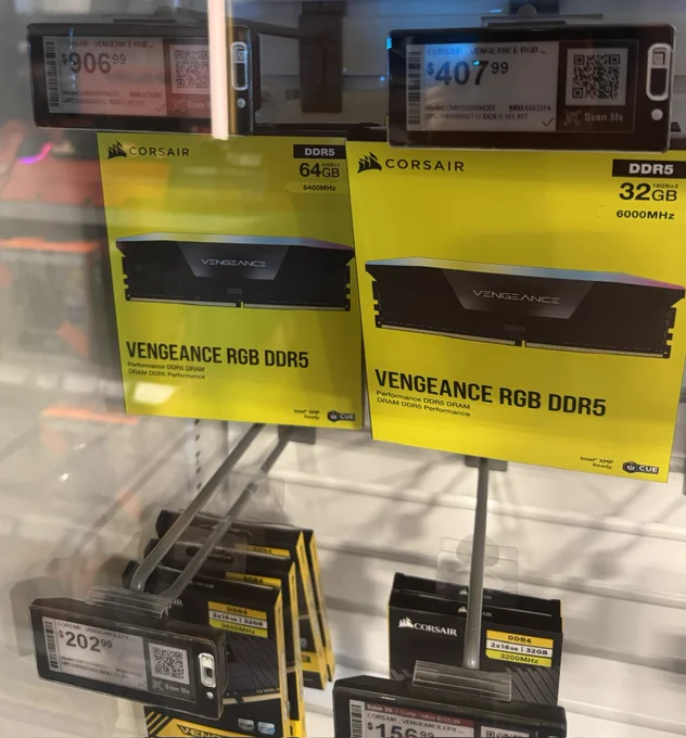 A picture of RAM hanging on a rack in-store. 64GB of Corsair Vengeance RGB RAM at $906.99 US. 32GB next to it at $407.99. DDR4 underneath at _mostly_ sane prices.