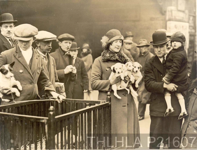 People buying and selling puppies at Club Row Market circa 1925.