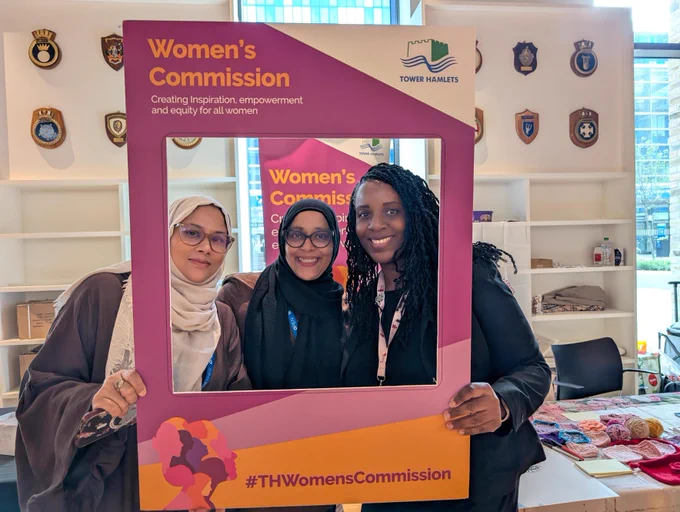 Three women looking through a selfie frame