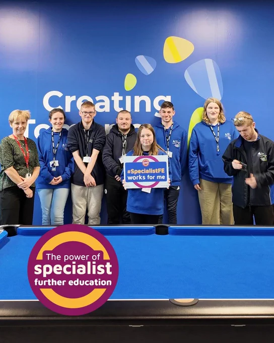 Clare at Creating Tomorrow College with a group of students, one of whom holds a pledge board saying "specialist FE works for me"