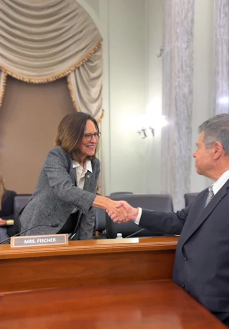 Robert Mayer, Senior Vice President of Cybersecurity and Innovation, shakes the hand of Sen. Deb Fischer before a Senate Commerce committee on evolving threats the telecom industry is facing. 