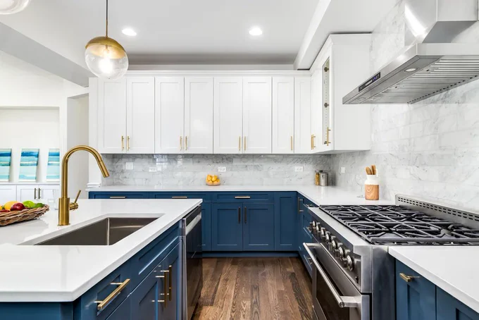 Freshly renovated kitchen featuring bold blue cabinetry with elegant brass accents