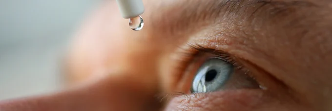 Photo of an eye with an eyedrop about to go into. 