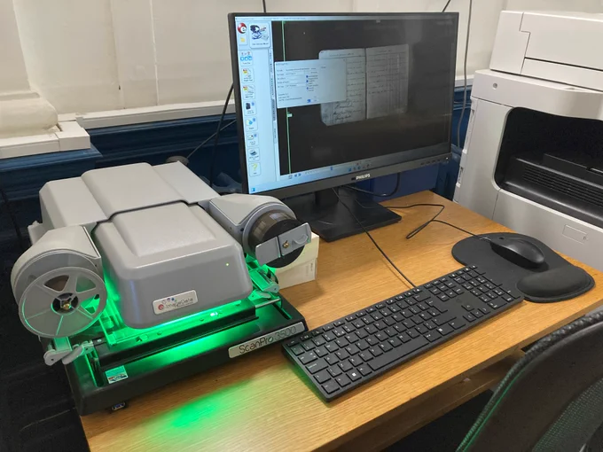 A digital microfilm reader scanning pages from an archive document.