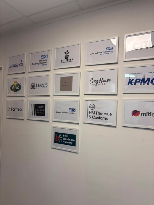A wall of framed logos of various employers logos