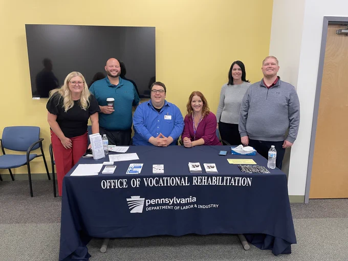 Pittsburg OVR staff smile for a photo at a table with OVR info.