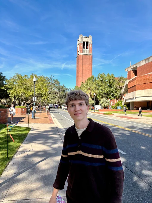 Bryan Weiksnar on the University of Florida campus with the bell tower in back of him at a distance.