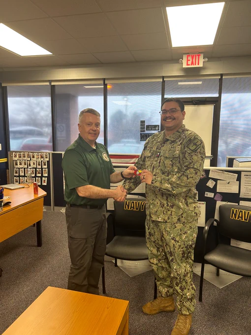 Rear Adm. James Waters, Commander, Navy Recruiting Command, presented Engineman 1st Class Rivera with a Navy Recruiting Command belt buckle for excellence while meeting with recruiters and staff at Navy Recruiting Station Fredericksburg on Dec. 2.