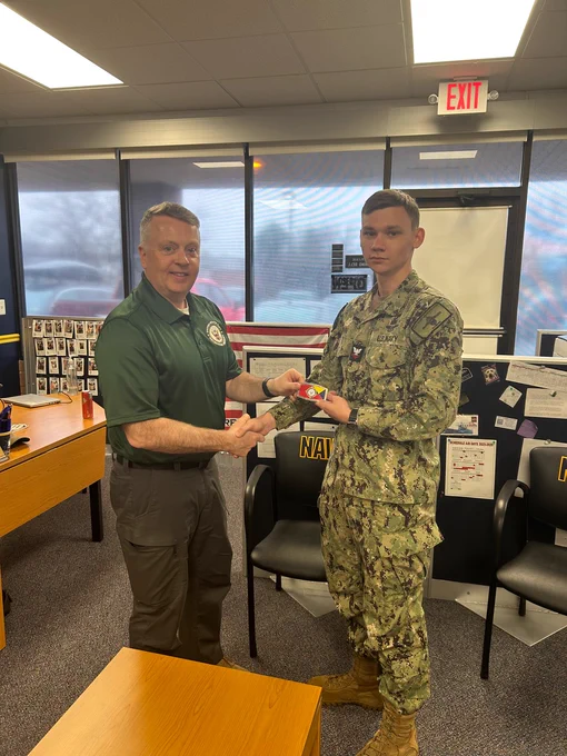 Aviation Structural Mechanic 2nd Class Ginn received a Navy Recruiting Command belt buckle for excellence from Rear Adm. James Waters, Commander, Navy Recruiting Command,  during his visit to Navy Recruiting Station Fredericksburg on Dec. 2.