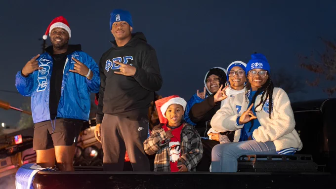 Six Henderson State fraternity and sorority students at the 2025 Arkadelphia Christmas Parade. 