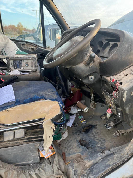 Interior of light goods commercial vehicle - wires hanging from dashboard and litter covering most of the interior