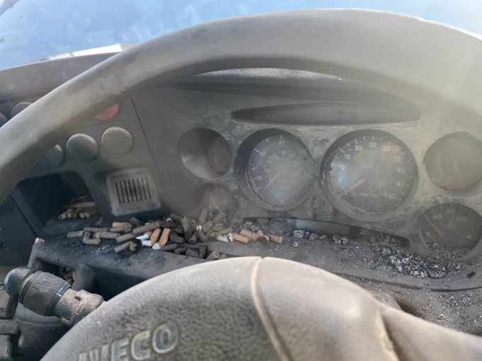 Interior of light goods commercial vehicle - dashboard full of disgarded cigarettes