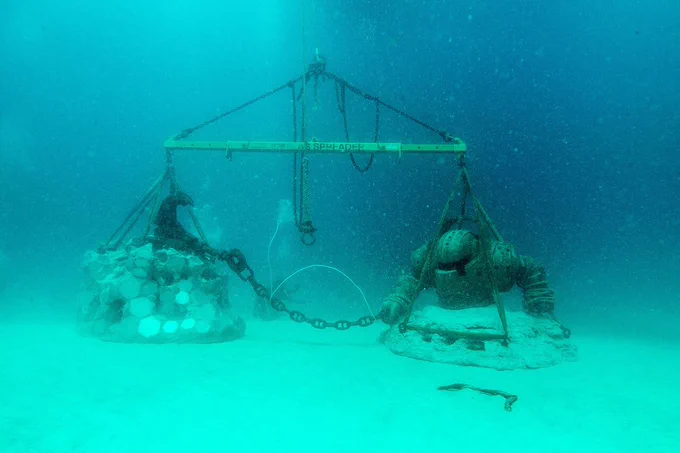 A Nautilus statue sits submerged on the ocean floor.