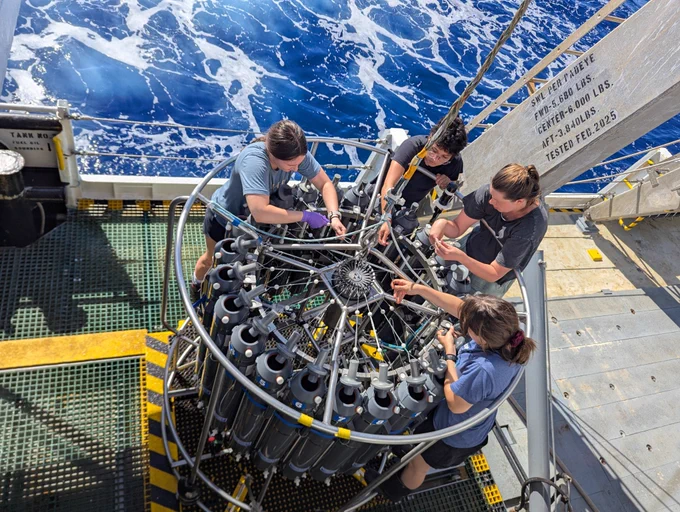 Members of the cruise team work together to prepare the CTD rosette for deployment. Photo by Claire Garfield. 