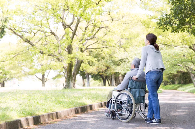 Girl pushing a man in wheelchair
