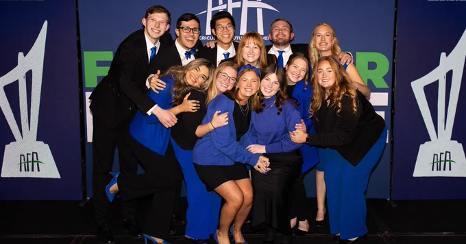 Group of individuals in blue attire posing at an AFA event.
