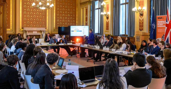 A large U shaped table with delegates sat facing inwards at last years model NATO event 