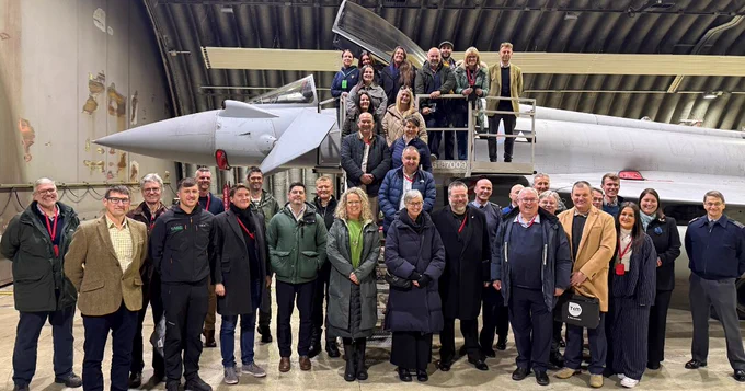 People standing in front of a Typhoon aircraft.