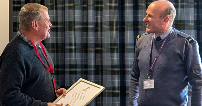 The owner of Here's How To holding the Armed Foces Covenant certificate next to Air Officer Scotland.