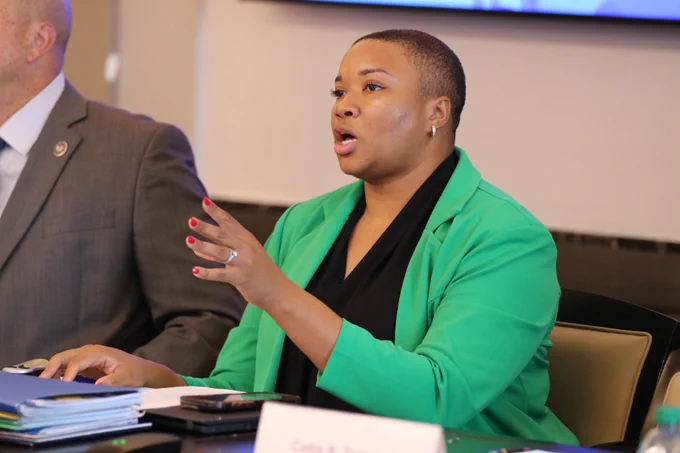 A woman in a green blazer leads a business discussion