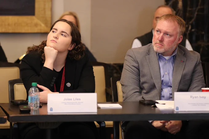 A woman and a man look at a presentation during a meeting