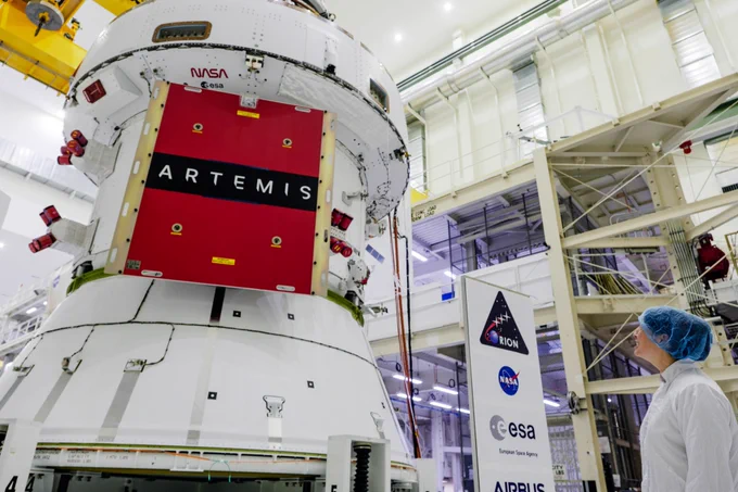 Branelle Rodriguez looks over the Artemis II Orion spacecraft following solar array wing installation in the Operations and Checkout Facility at NASA’s Kennedy Space Center in Florida. Credit: NASA