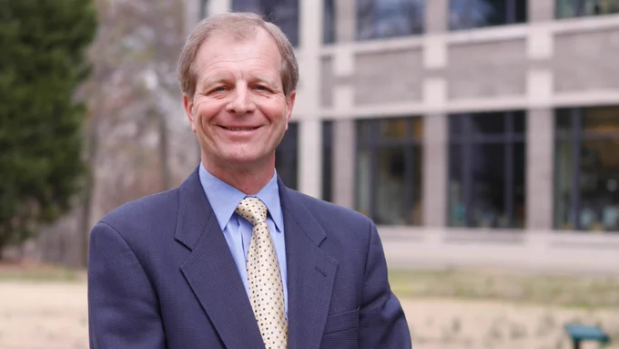 Ken Dodge standing outside, dressed in a suit, smiling.