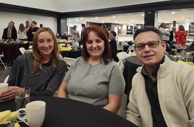 Three WLUFA Members smiling for a picture at their table