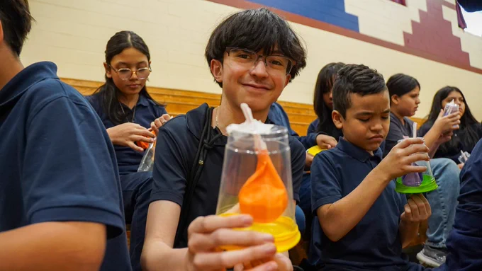 Boy holding a handmade science model of the heart and lungs of a human and showing it to the camera