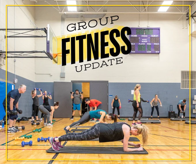 Group fitness class taking place in a gymnasium with "Group Fitness Update" across the top of the photo.