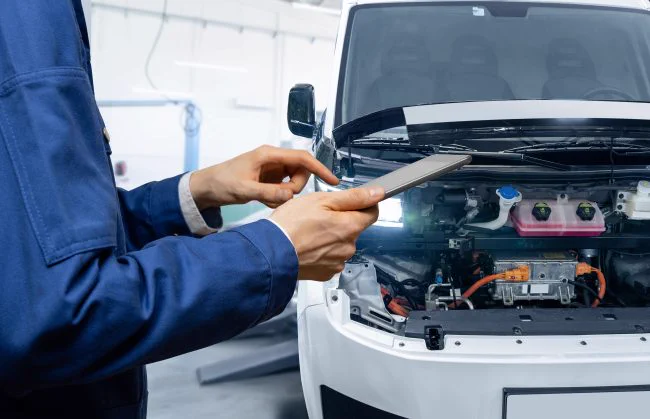 automotive professional diagnosing electric vehicle