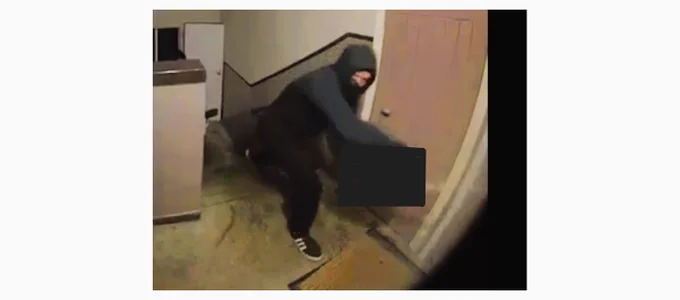 Man with all black clothing approaching a door