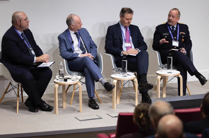 Four panel members sat on chairs presenting.