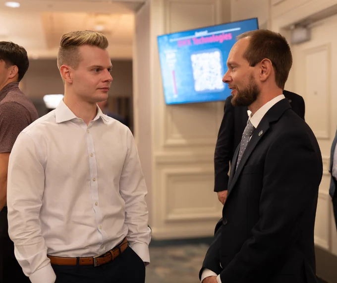 A Stetson student and professor in business attire engage in conversation at the RGIP showcase.