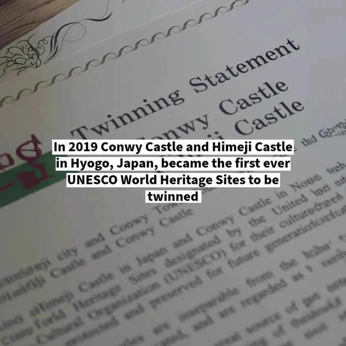 Close-up of a twinning statement document highlighting the partnership between Conwy Castle and Himeji Castle as UNESCO World Heritage Sites - with the text 'In 2019 Conwy Castle and Himeji Castle in Hyogo, Japan, became the first ever UNESCO World Heritage Sites to be twinned'