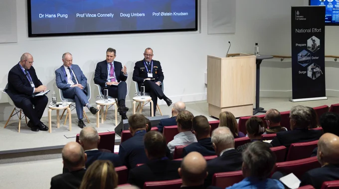 Four panellists speaking to an audience.